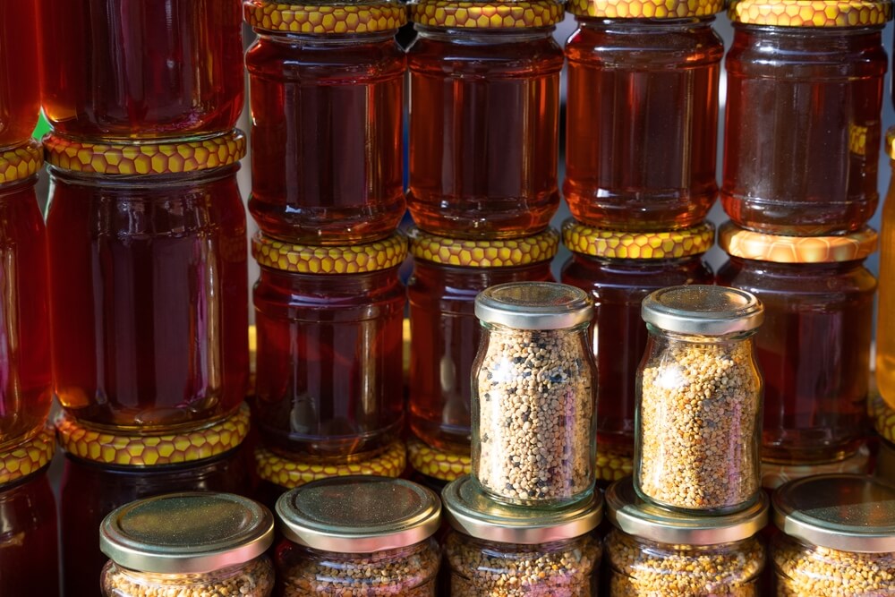 Tmavohnedý a zlatý med balený v pohároch